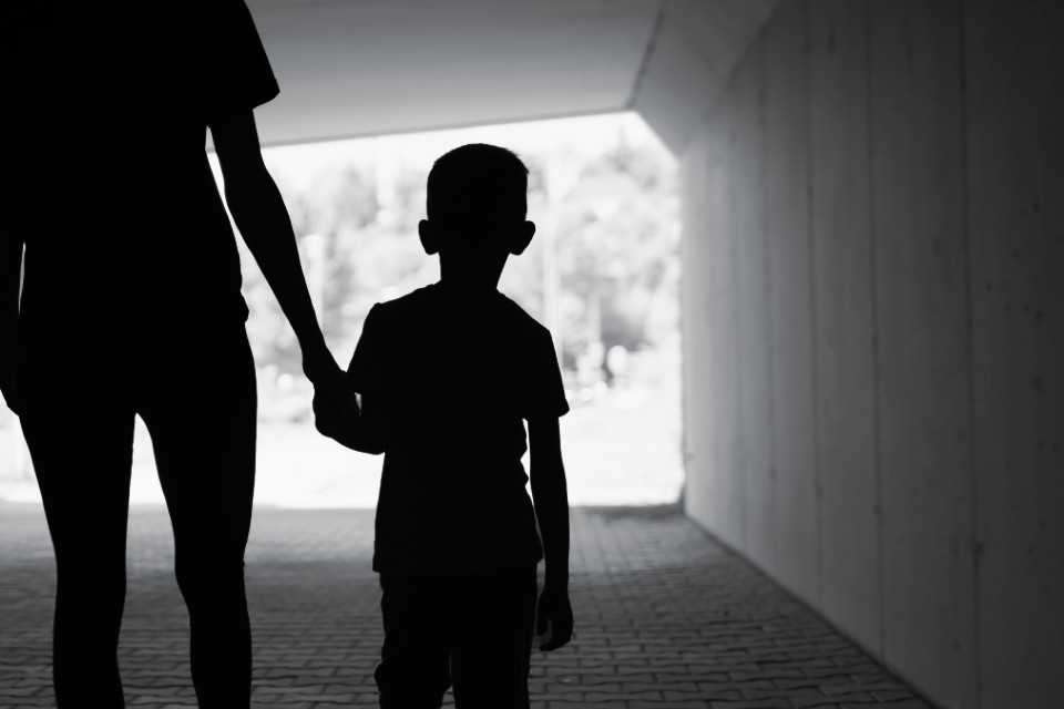 Image of child walking holding hands with adult.