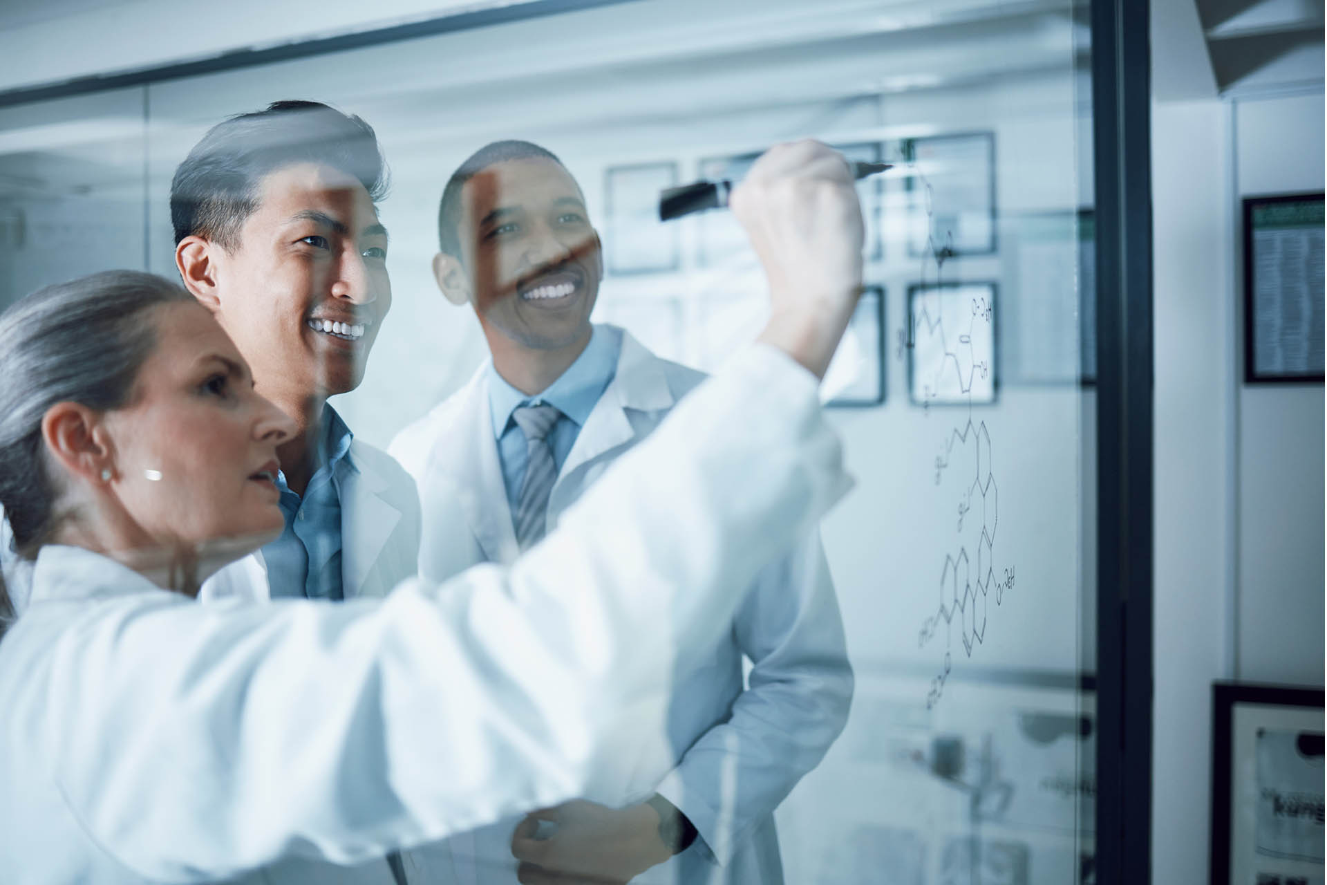 group of scientists working on a white board discussing data