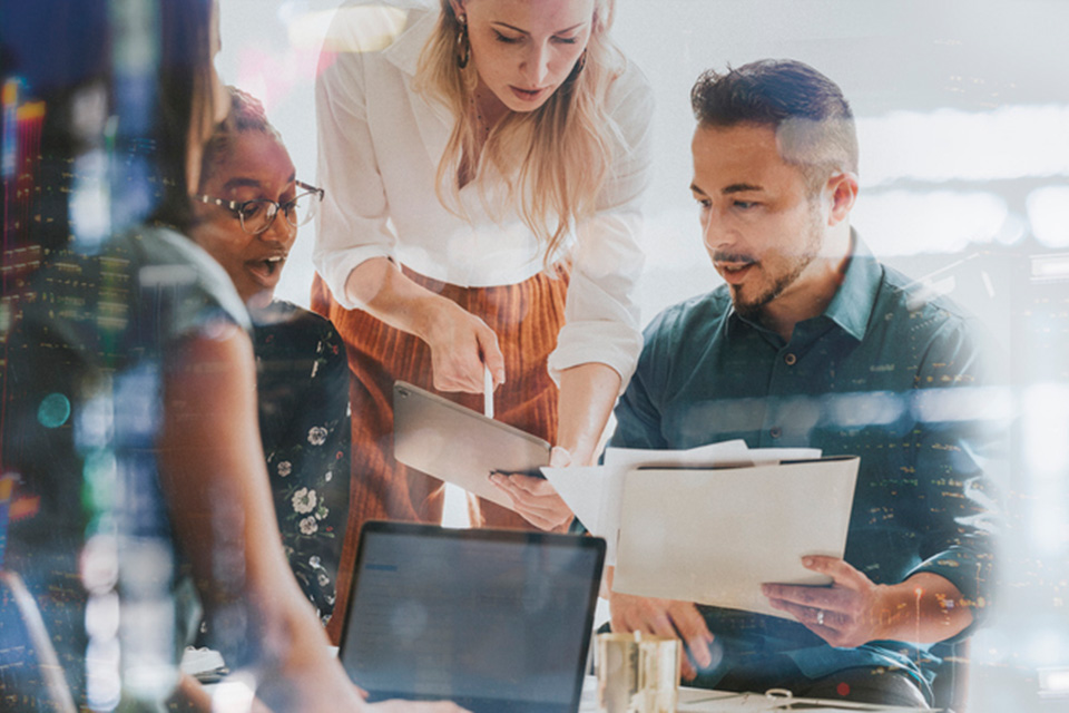 group of colleagues sitting around a small table discussing work