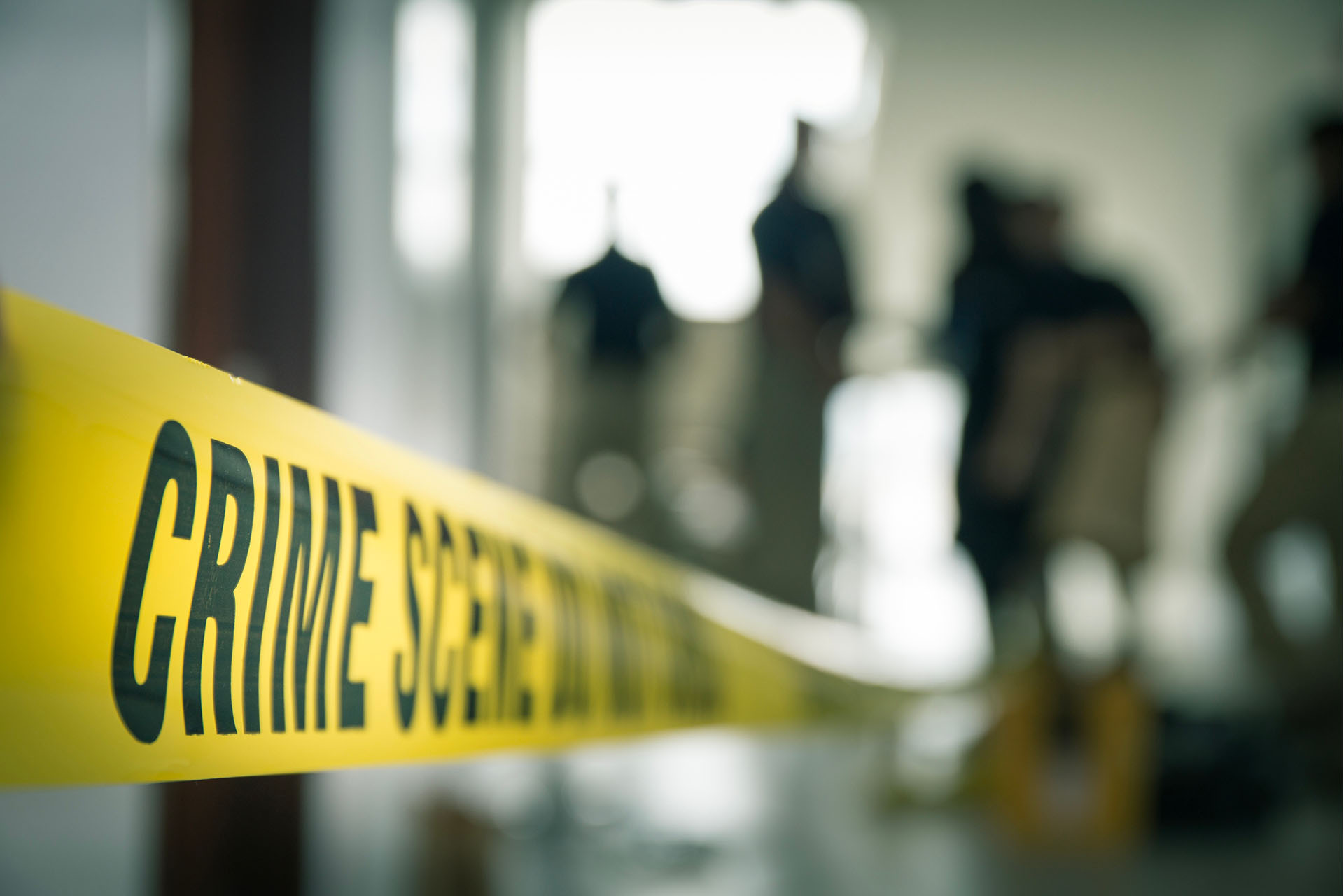 image of police tape and crime scene being investigated