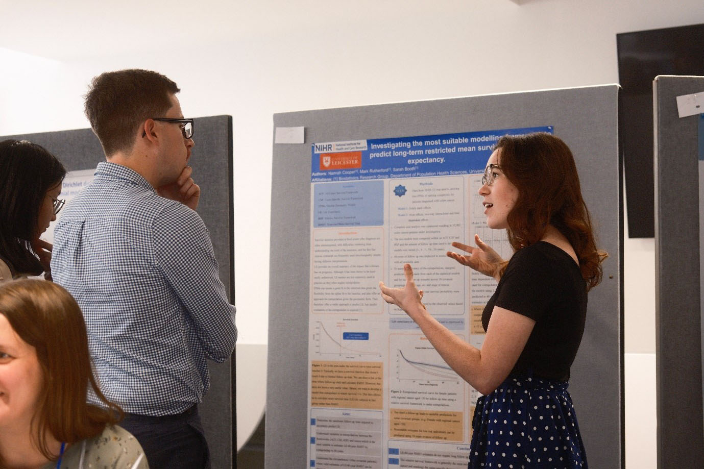 Student at the young statisticians meeting explaining their poster presentation to an attendee