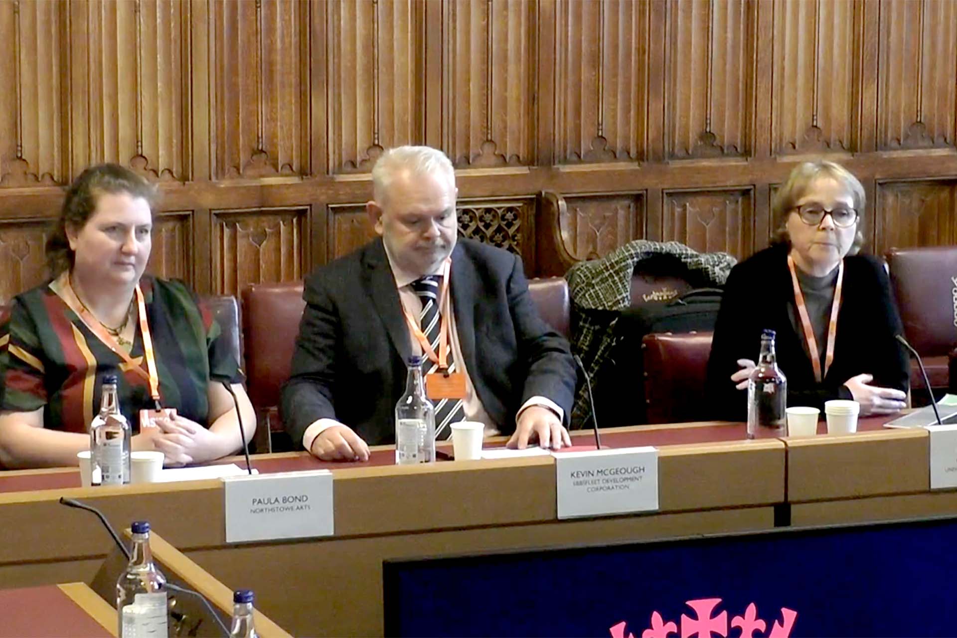 Professor Rhiannon Corcoran at Parliamentary Committee Hearing, sat on panel with three colleagues in wood lined room arranged in a circle.