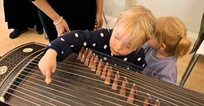 Small children touching the guzheng at Meet the Scientists
