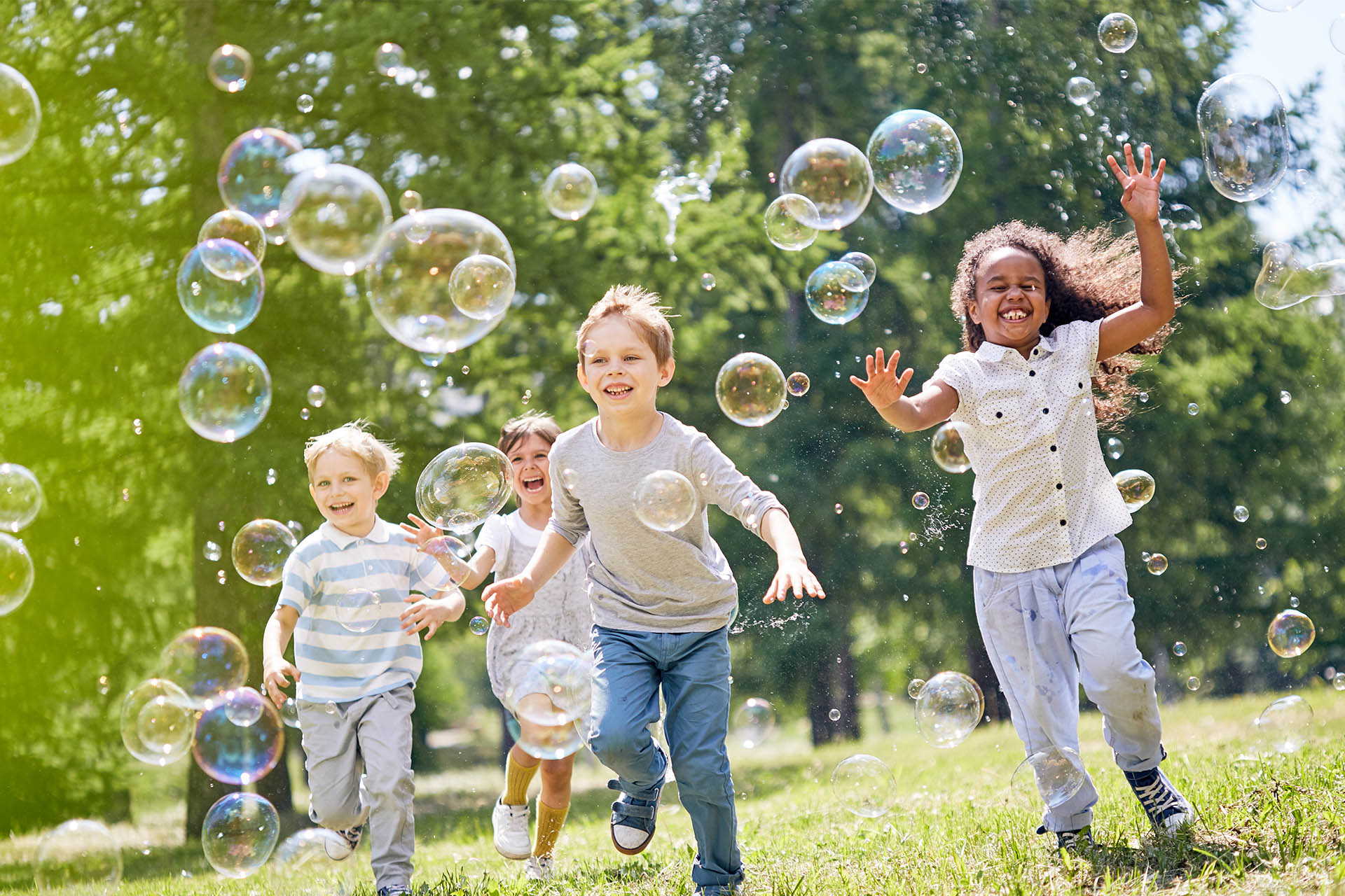 Children chasing bubbles in garden