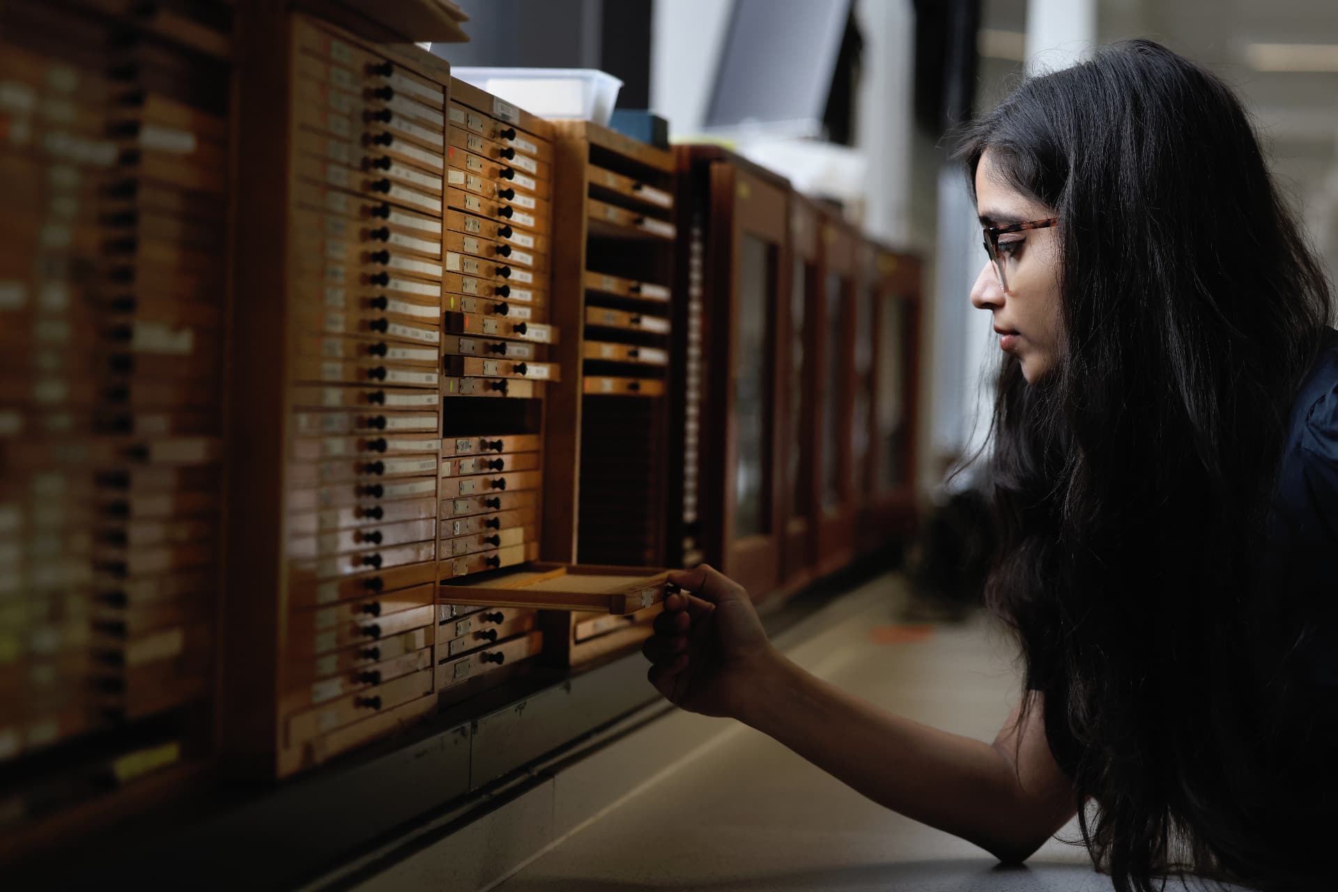 Female postgraduate student in the library opening a