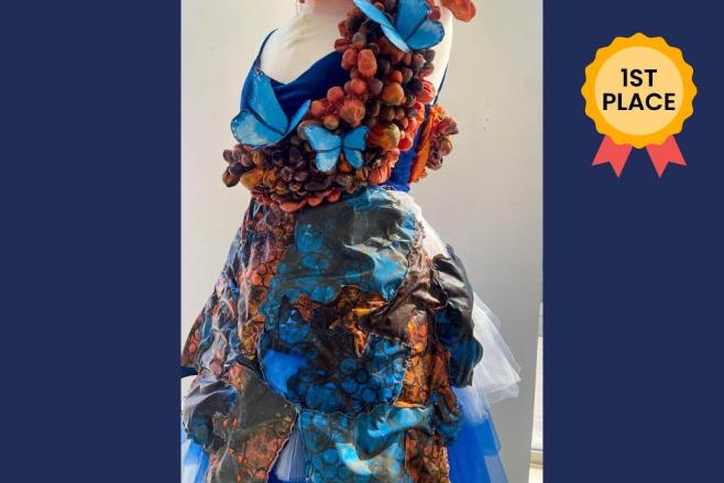 An image of a handmade dress against a navy blue background with a 1st place medal in the top right corner.