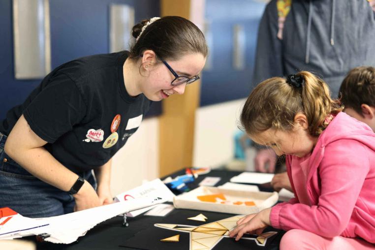 A female volunteer talking to a child attendee