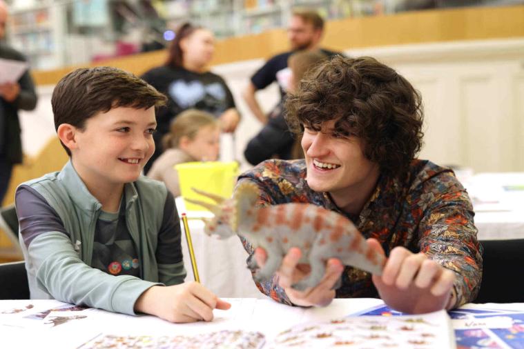 A male volunteer and a child at an activity table