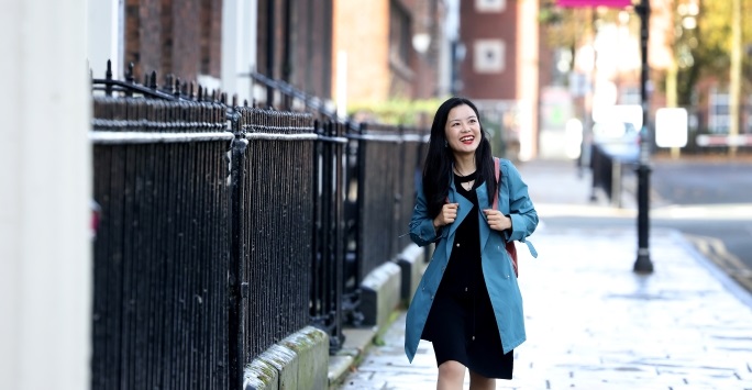 An international student smiles while walking around the University of Liverpool campus