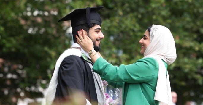 A mother hugs her son during his graduation ceremony