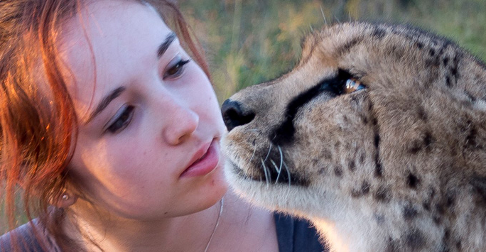 Megan McCubbin sitting by a cheetah PNG image