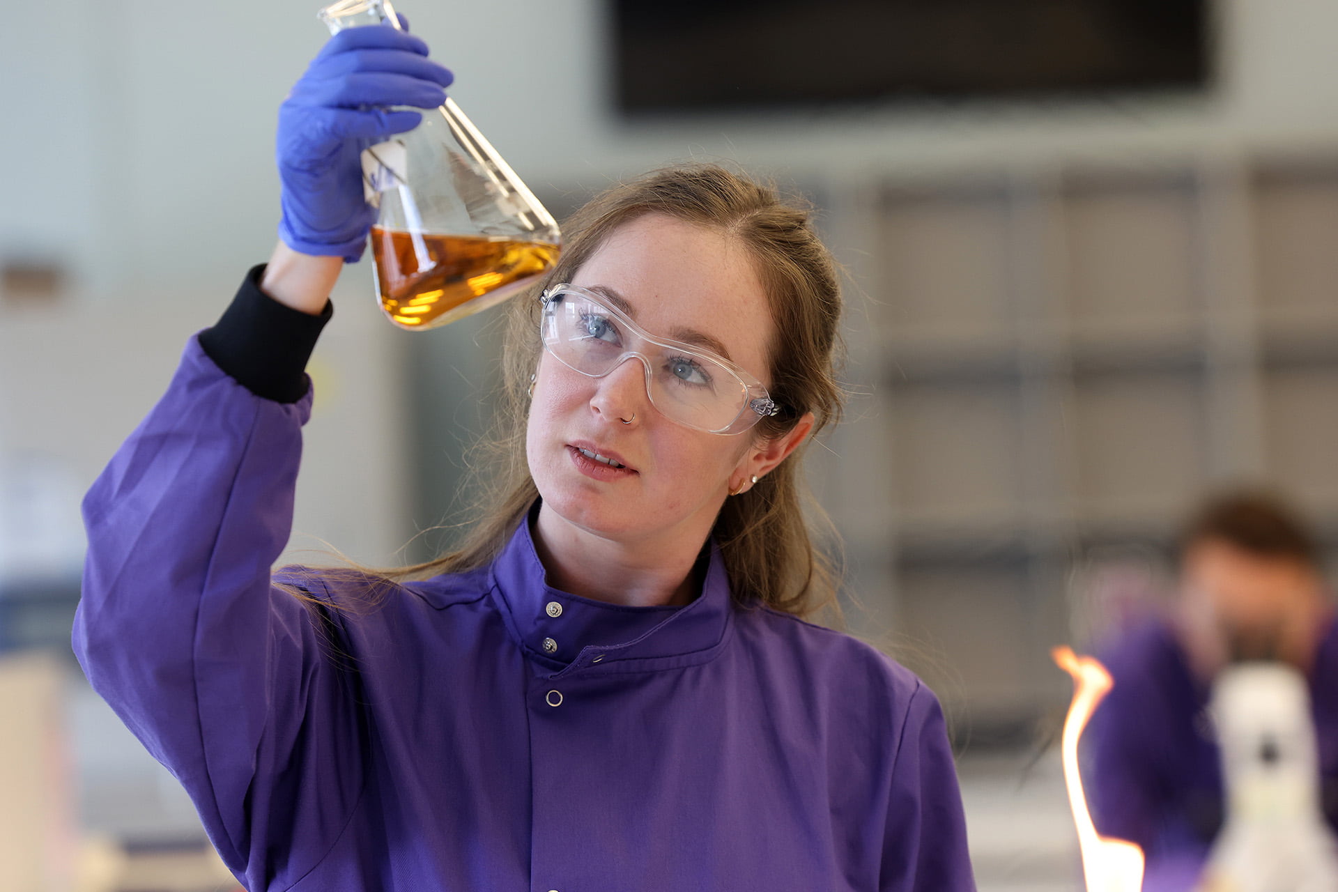 Female chemist in a lab looking at solution in a beaker