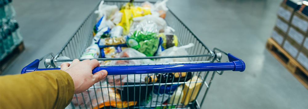 Man pushing trolley full of food in a shop