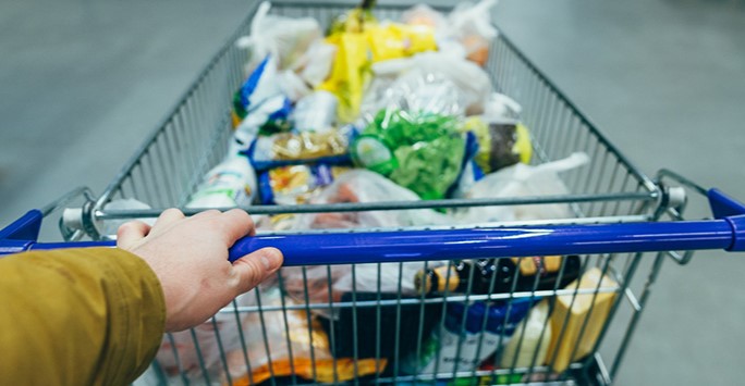 Man pushing trolley full of food in a shop