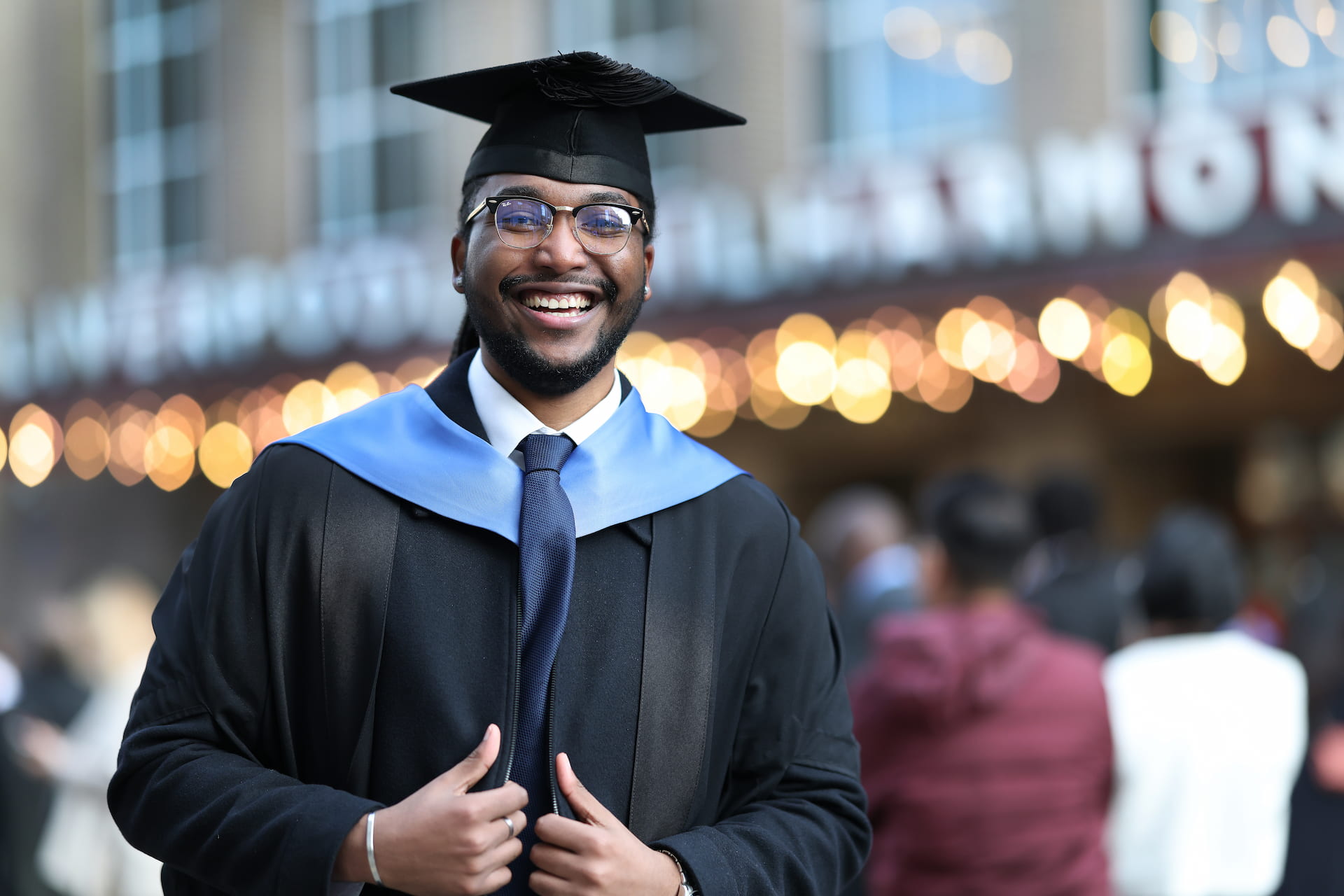 A smiling student wearing a graduation gown