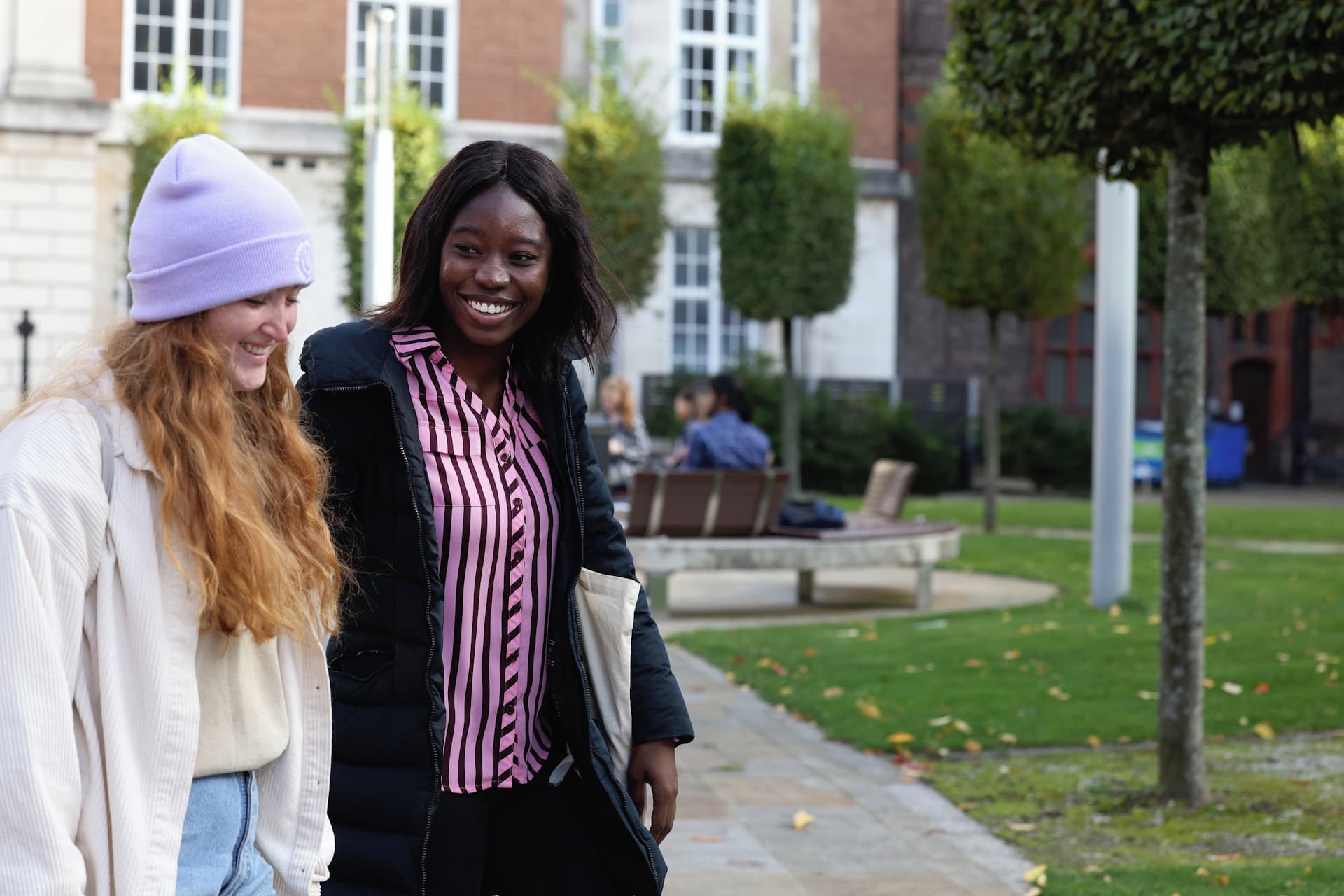 Two postgraduate students walking across the Quadrangle