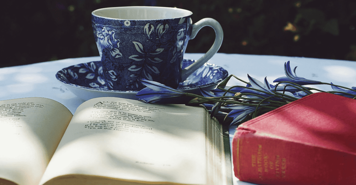 A book in the foreground is visible, with flowers and tea