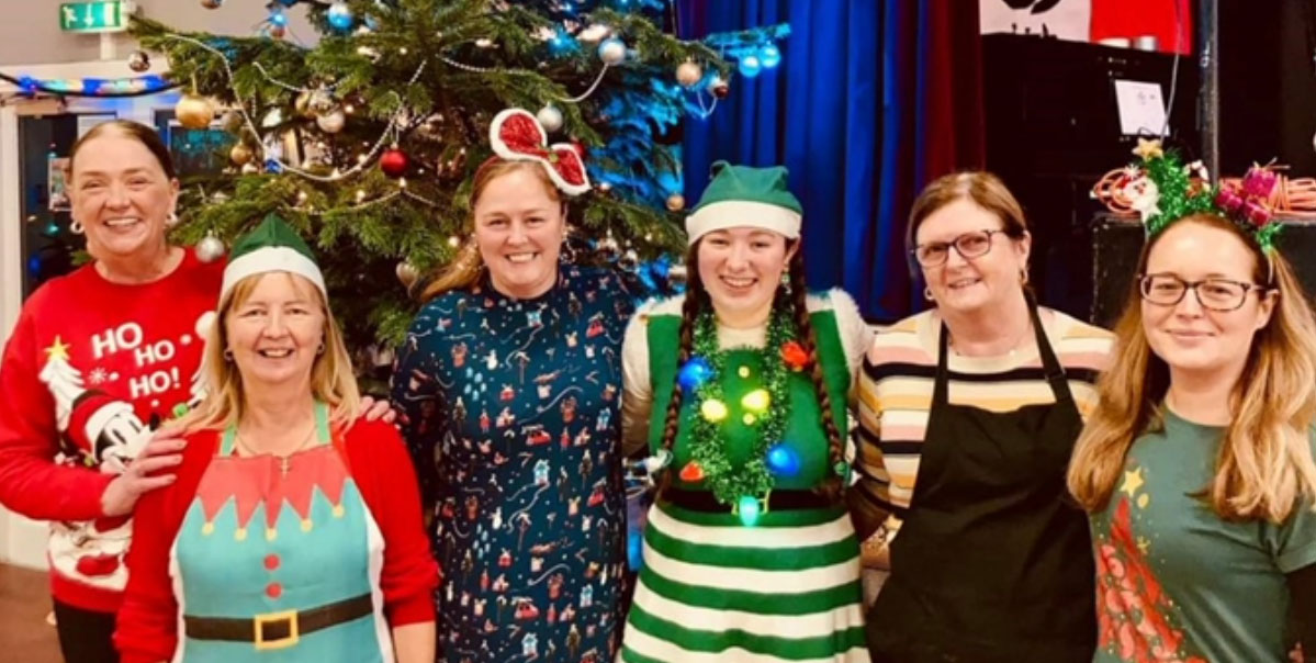 6 Irish Centre members posing in front of a Christmas tree