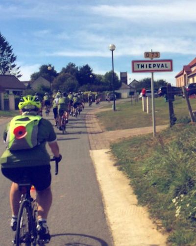 Line of cyclists riding on a road.