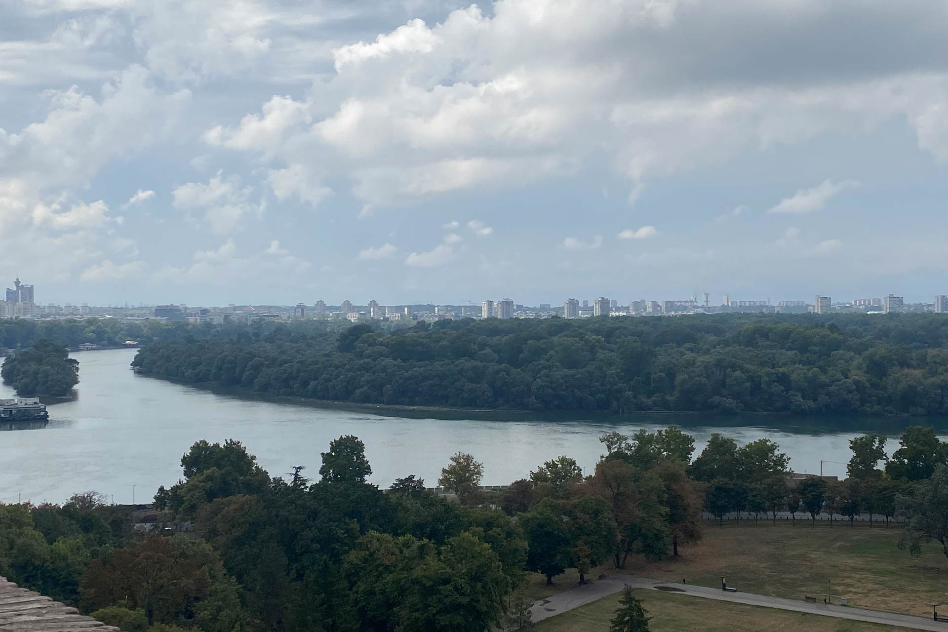 A river with trees surrounding it and a cloudy sky.