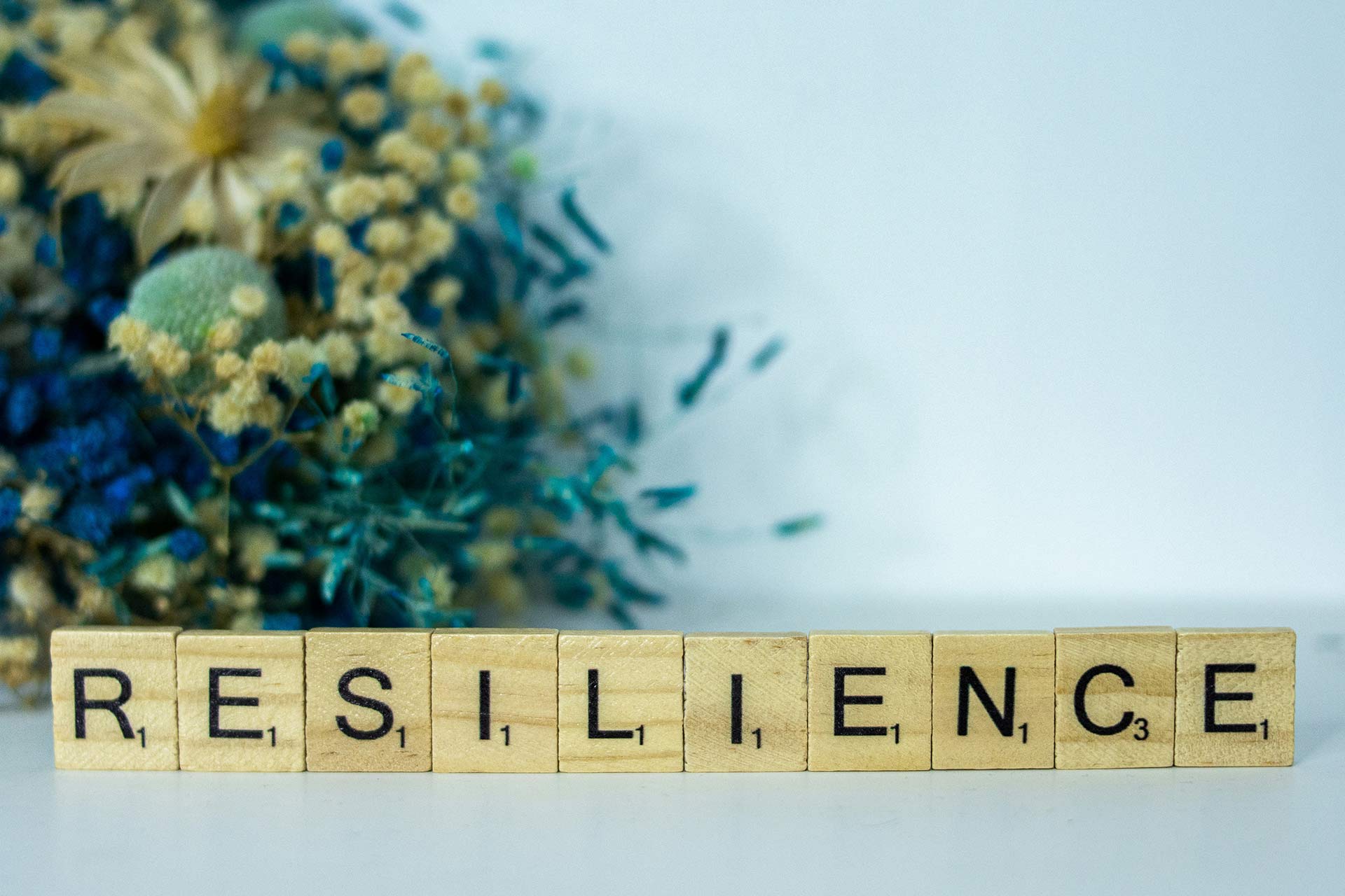 Scrabble letters on a table spelling out 'RESILIENCE'