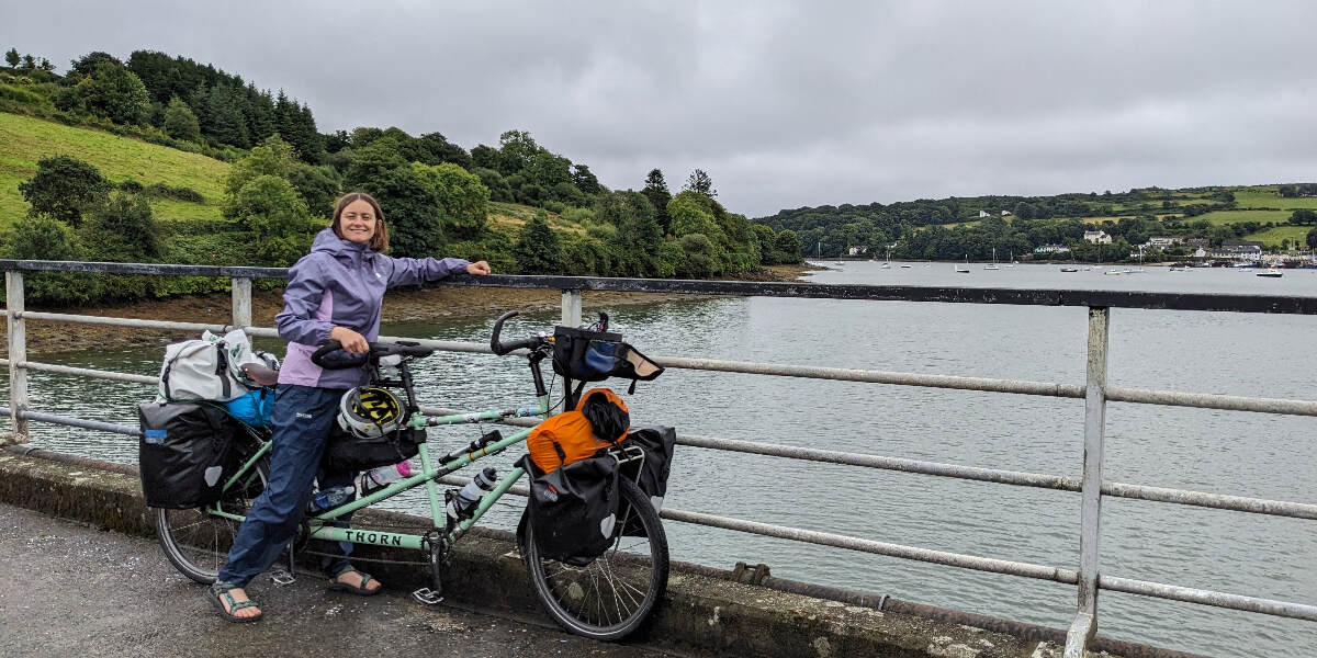 Jessica White with her bike posing next to a lake