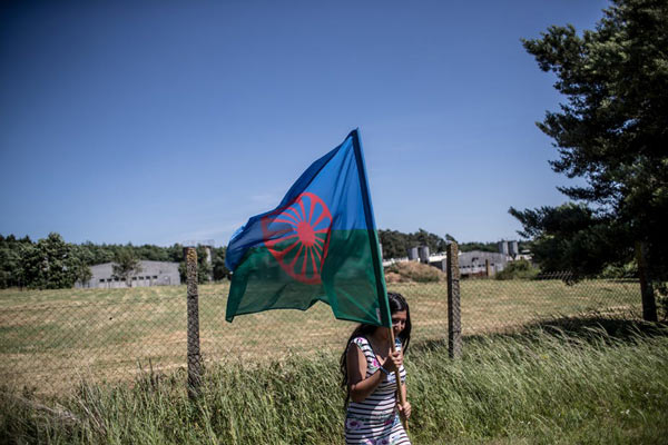 A woman holding a Roma flag