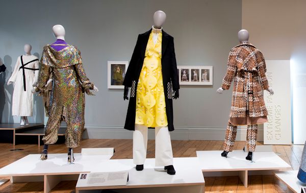 Mannequin with a yellow dress and black coat.