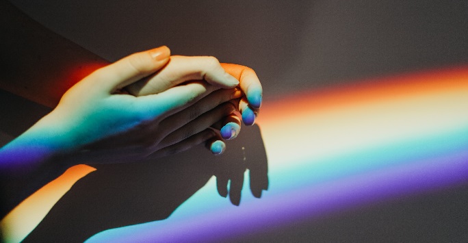 Hands with a rainbow projection