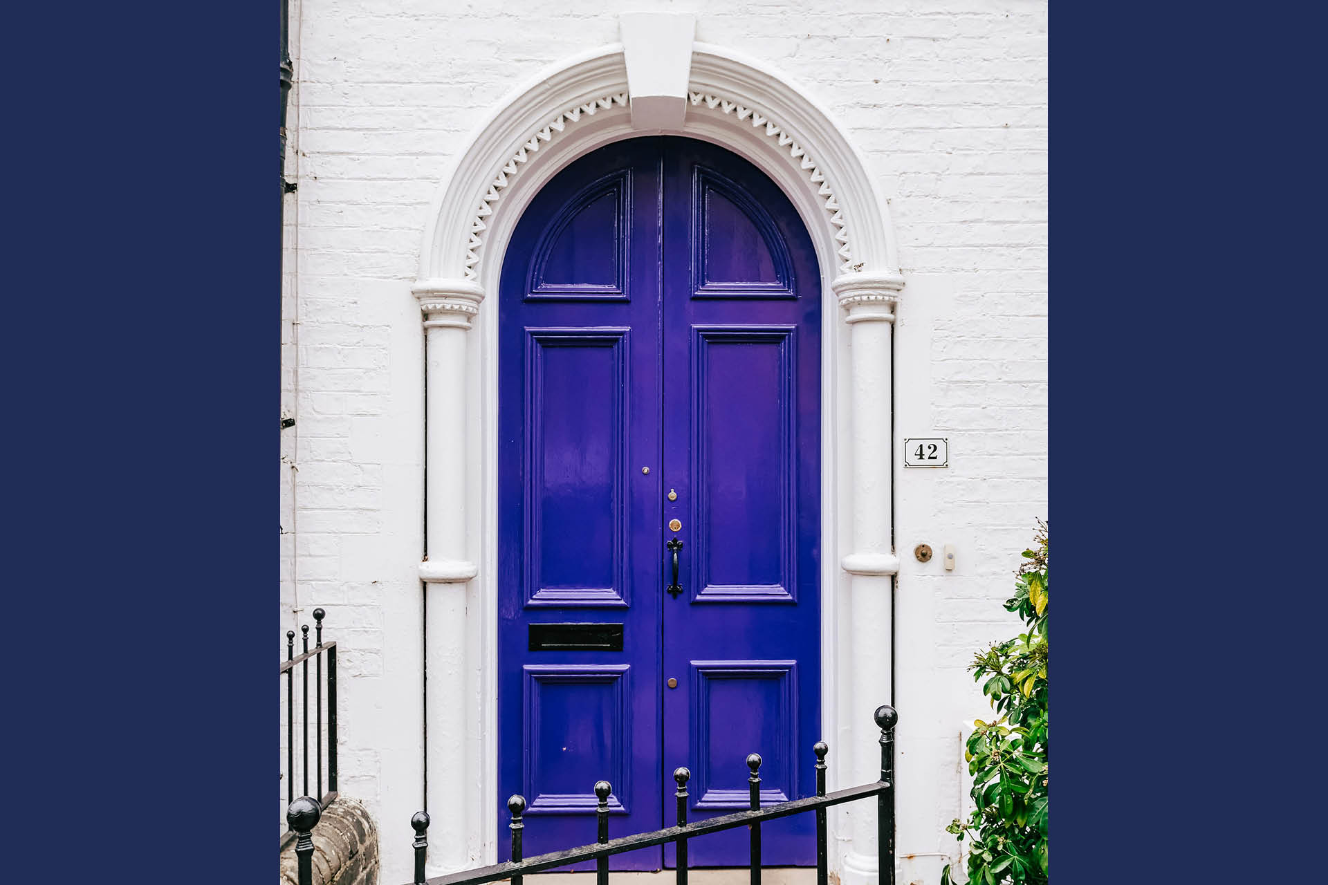 A blue front door in a white house