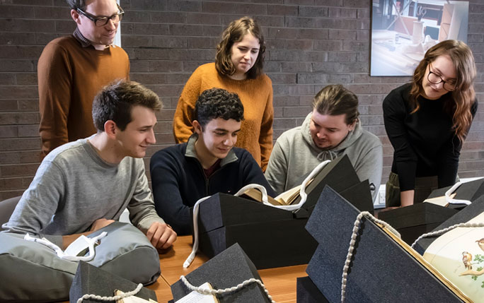 Students and academic looking at books in the Special Collections and Archives.