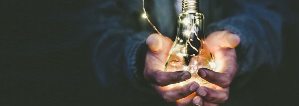 Hands holding a lightbulb