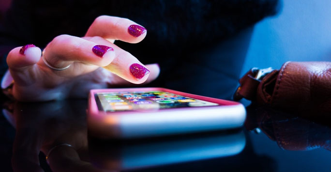 A woman's hand poised over a smartphone