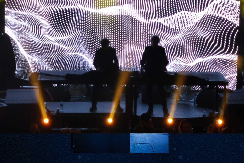 Two people silhouetted against the LED wall