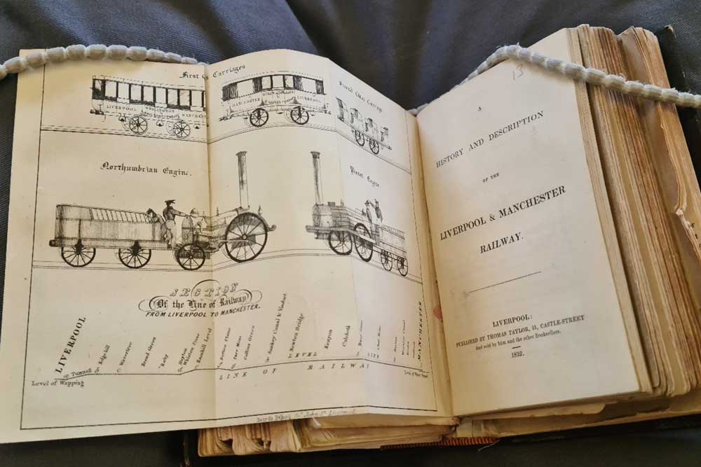 An open antique book on the Liverpool and Manchester railway.
