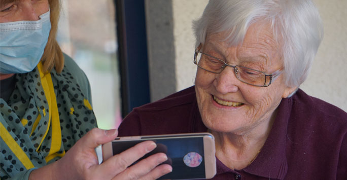 Care home resident looking at a phone