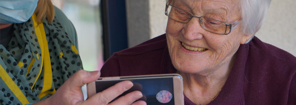 Care home resident looking at a phone