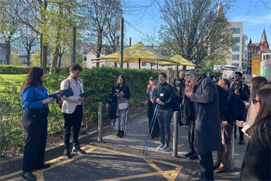 People standing outside listening to a tour leader