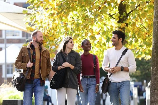 Lee Wainwright, Daniella Trimmis, Namonda Muyunda and Harsh Chaudhary walking on campus