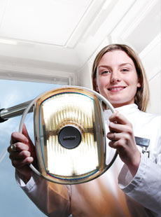 A feamle dentist holding a lamp