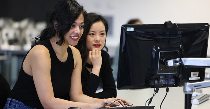 Two postgraduate students working together at a computer