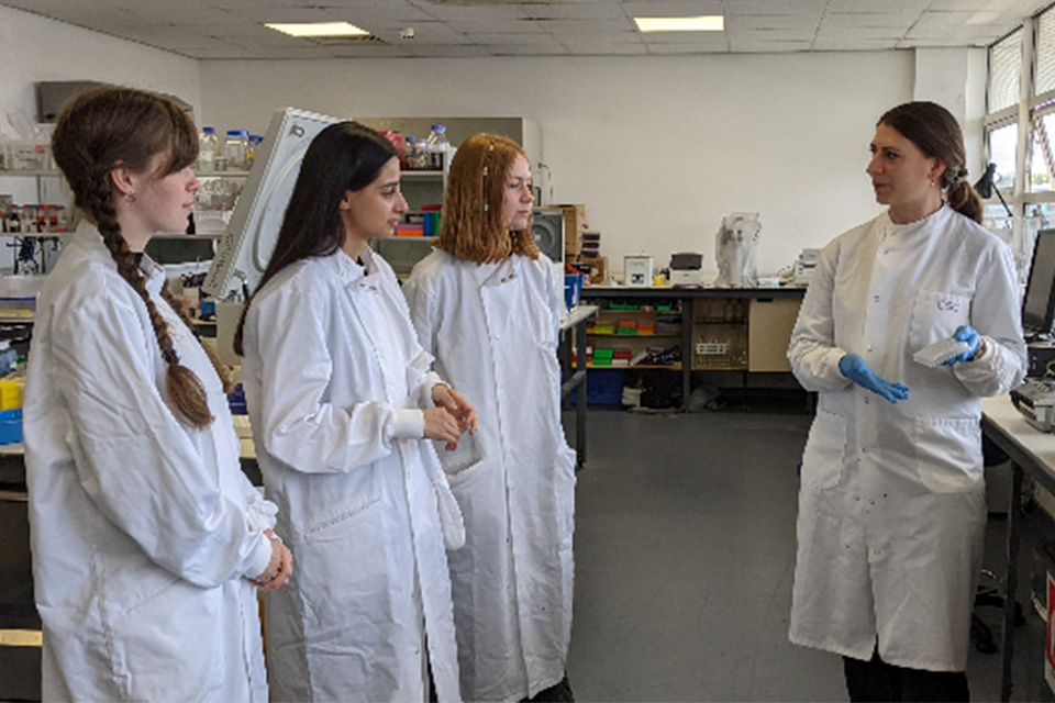 Female students being shown how to use equipment by female researcher