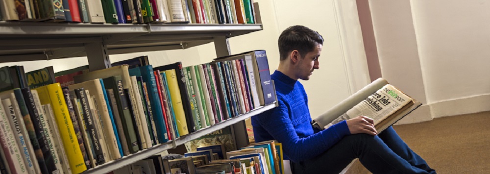 Student reading a book in the MacLua Library