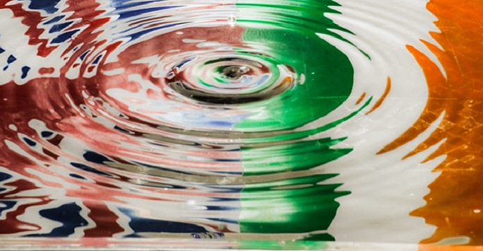 puddle reflection of union jack and irish tricolour flags 