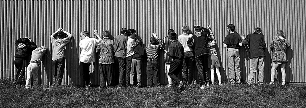 Children lined up against a barrier