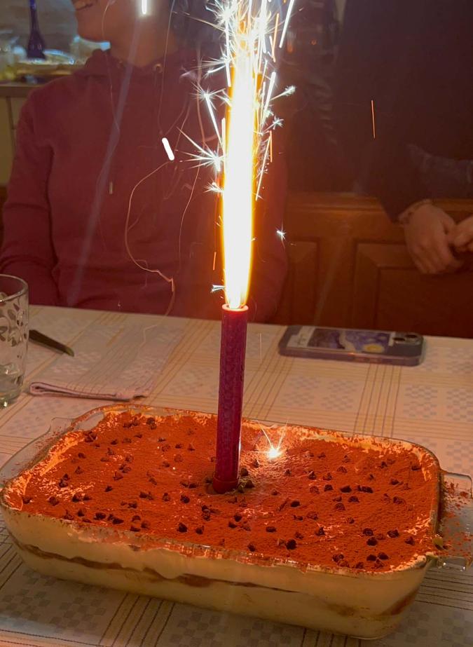A tiramisu Birthday Cake with a sparkler on top
