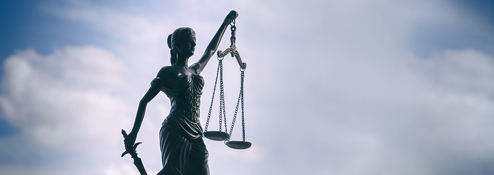 Image of Lady Justice with background of the sky