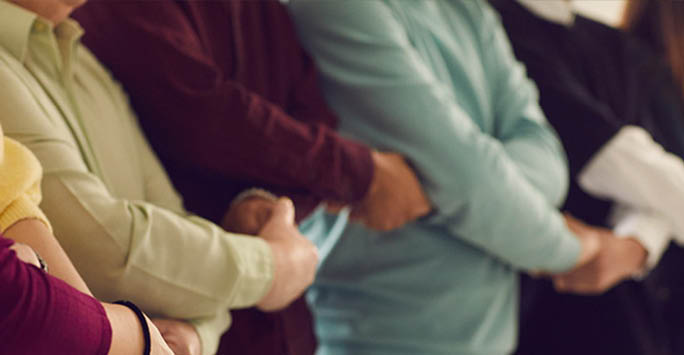 A line of people with crossed arms.