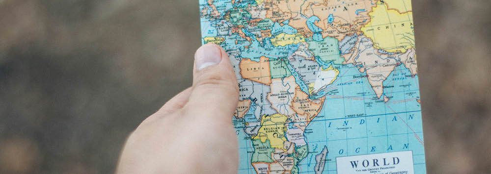 A person holding a map of the world.