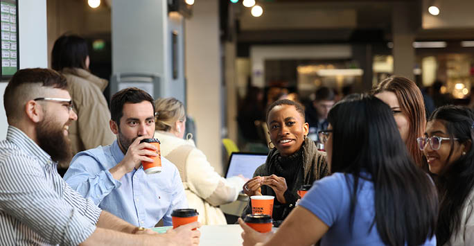 A group of people sat around a table working collaboratively.